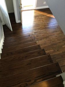 Staircase with dark stained wooden steps leading to a doorway, transitioning to a light wood floor.
